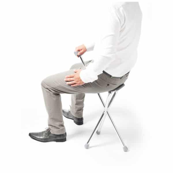 Kavelykeppi istuin mies istuu kävelykepin tuoliosalla.