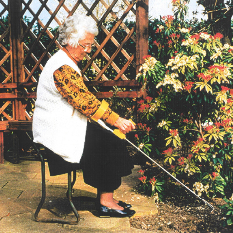 Puutarhanhoitoa tuolissa istuen. Kätevä istutushara pitkävartinen ergonominen Easi-Grip PLR-C ei rasita rannetta e puutarhassa työskennellessä.